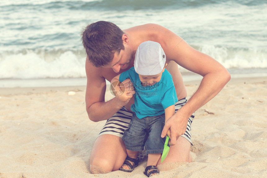 父亲和儿子在沙滩上玩耍图片