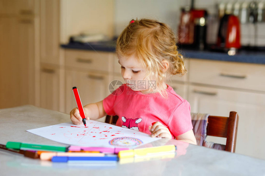 可爱的小蹒跚学步的女孩在家里用彩色铅笔画可爱的健康快乐的孩子使用毡尖笔学习绘画活跃的孩子在室内或托图片