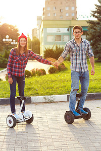 年轻夫妇骑气垫板电动滑板车个人生态交通工具陀螺滑板车智能平衡轮图片