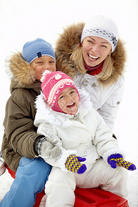 快乐的孩子们和他们的母亲坐在滑雪车上图片