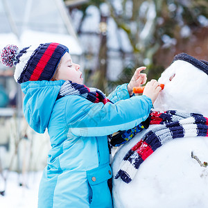 可爱的男孩做雪人图片