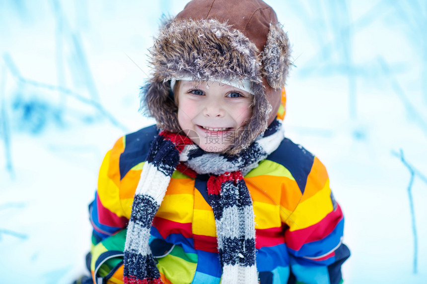 在降雪期间在户外穿着五颜六色的冬装的孩子男孩的冬季肖像冬天与孩子们一起积极户外休闲有温暖的帽子手套图片