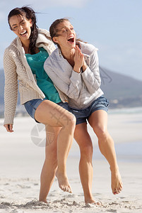 两个无忧虑的女人的肖像在海滩图片