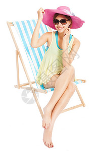 年轻阳光女孩笑着坐在沙滩椅子上图片
