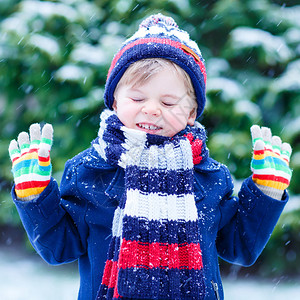 快乐的小滑稽孩子穿着五颜六色的冬装图片