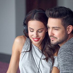 幸福的年轻夫妇在室内耳背景图片