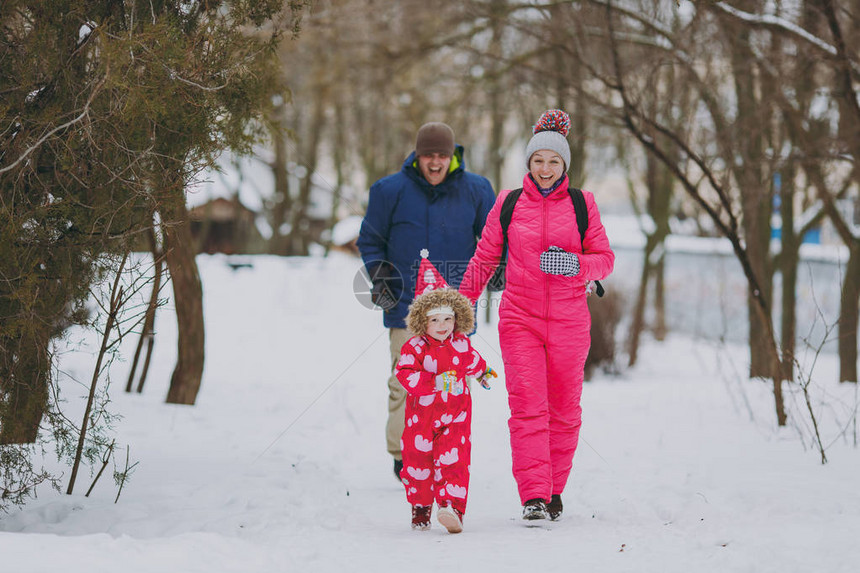 欢笑的家庭妇女穿着温暖衣服跑步的男小姑娘在雪地公园或露户森林中行走冬季娱乐节假日休闲爱童关系家庭生活方图片