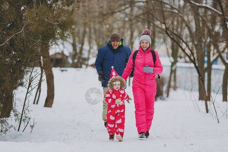 爸气方刚欢笑的家庭妇女穿着温暖衣服跑步的男小姑娘在雪地公园或露户森林中行走冬季娱乐节假日休闲爱童关系家庭生活方背景
