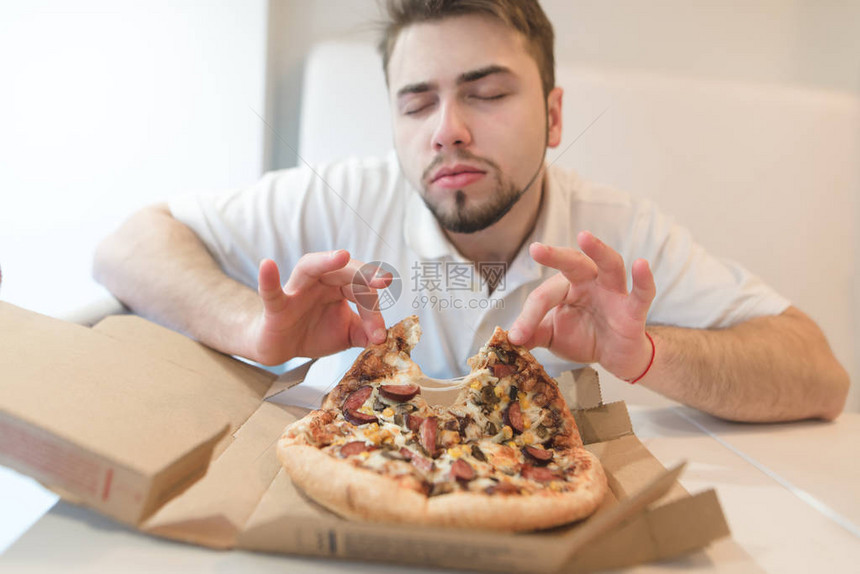 一个好人会从披萨的香气中获得乐趣一个闭着眼睛的人从纸板箱里拿图片