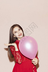 穿着红色衣服的漂亮女孩拿着气球情人节生日妇女节周年纪念日图片