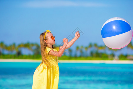 小女孩在沙滩上玩球图片