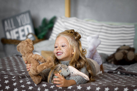 小女孩在床上玩具熊图片