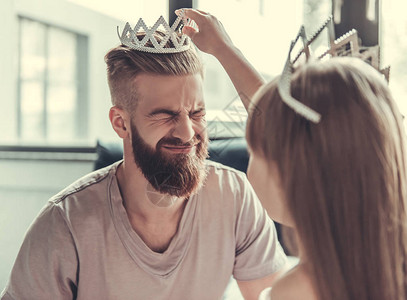 可爱的小女孩和她英俊的长胡子爸在皇冠上笑着微笑图片