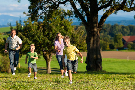 欢乐的家庭户外快乐的户外活动在美丽的夏日在草地上奔跑他们图片