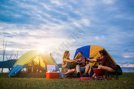 一群男人和女人在湖边享受野营餐和烧烤图片
