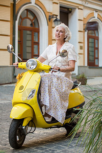 骑黄色摩托车的女士图片