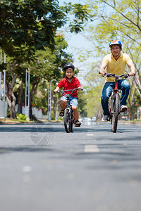 亚洲父子一起享受骑自行车图片