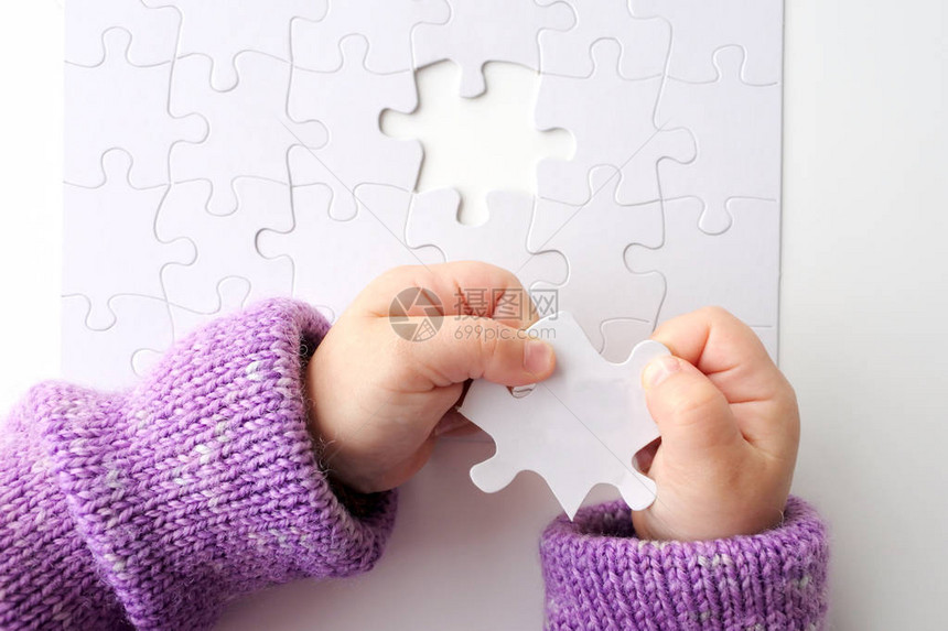 儿童手握着拼图中最后一个拼图的拼图解决问题的概念图片