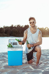 在沙滩上从便携式冰箱里取啤酒的年图片