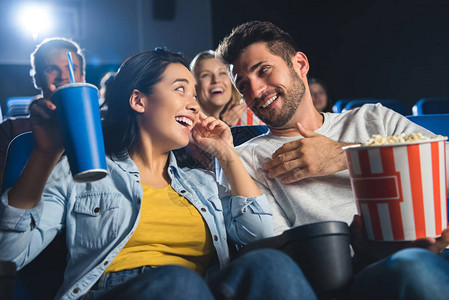 有爆米花一起在电影院看电影的一对幸福的图片