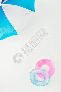 海滩雨伞和充气环的顶部视图它们被背景图片