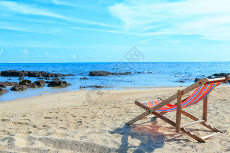 在海滩的一张空的木沙滩椅图片