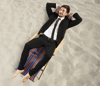 躺在沙滩椅上的年轻商人图片