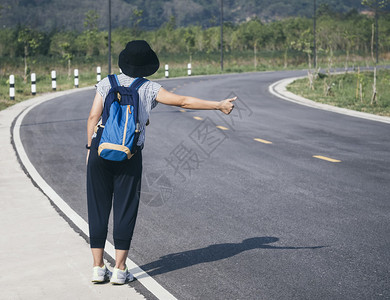 在公路上旅行概念中带后背包图片