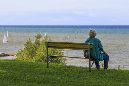 年长的女人独自坐在港口一旁看望着图片