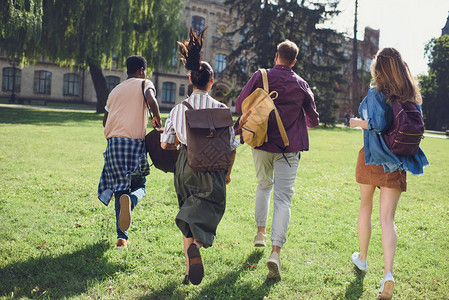 快乐的多元文化学生在公园里跑上大图片