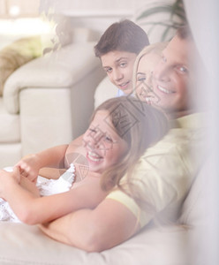 幸福的家庭微笑看着客厅窗户玻图片