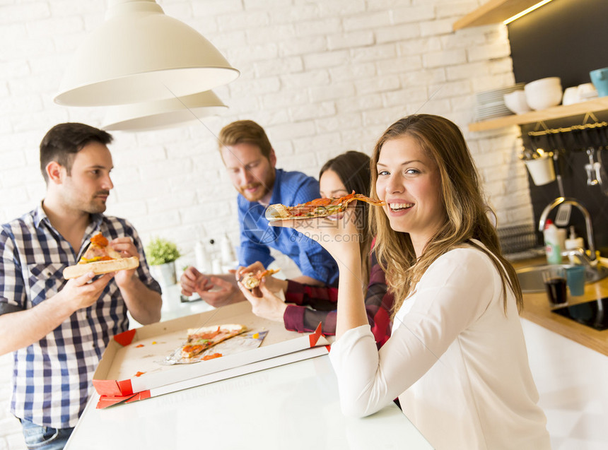 一群朋友在家一起吃披萨图片