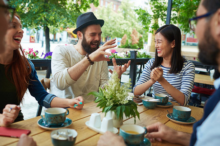 戴帽子的胡子男人在咖啡馆里和朋友图片