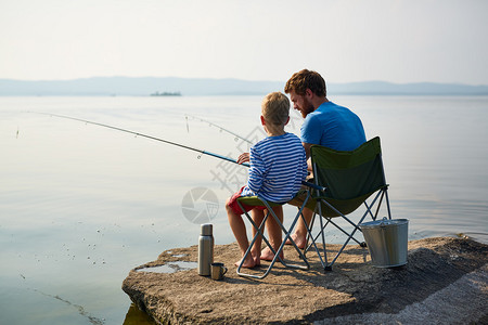 父亲和儿子在河里钓鱼图片