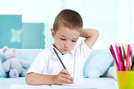 沉思的孩子正忙着做他的家庭作业图片