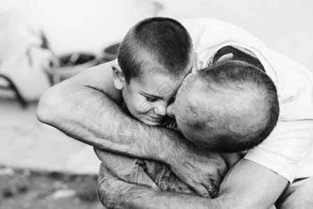 一个叔轻地拥抱亲吻他小侄子在黑白图片