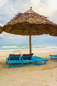 越南岘港海滩的棕榈叶和日光浴床它也被称为NonNuoc海滩背图片