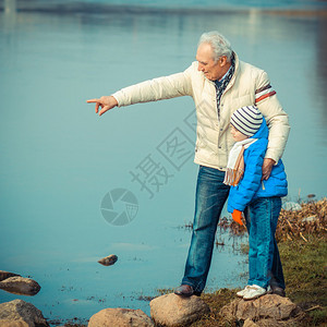 爷和孙子正试图在石头上过河图片