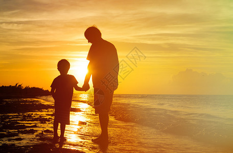 在日落海中手牵的父亲背景图片