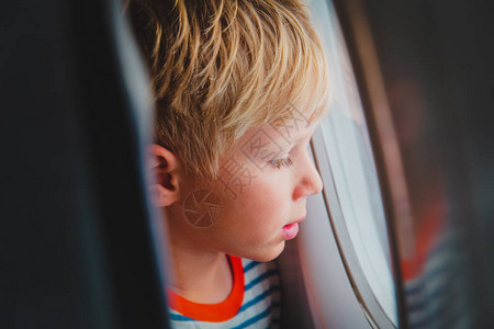 小男孩乘飞机通过窗户家庭旅行从小男图片