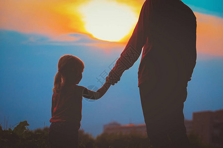 父亲和女儿在日落的天图片