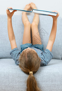 小女孩在沙发上看书图片