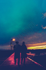在日落时的AMarina街灯下浪漫情侣的反向风格照片图片
