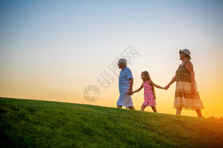 日落时女孩和祖父母在一起人图片