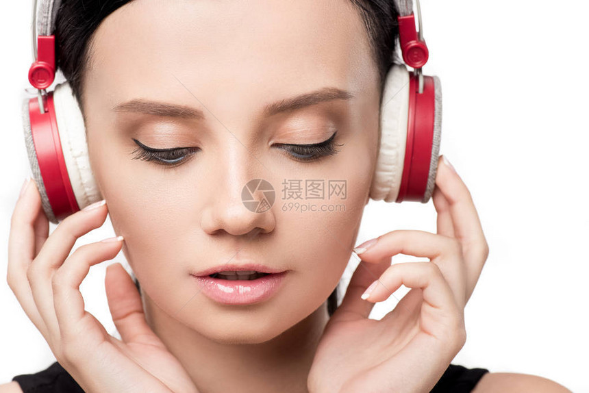 在白色的孤立耳机中监听音乐的有吸引力的女图片