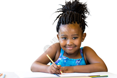 在桌子上拿着彩色铅笔的小非洲女孩的近距离肖像孤图片