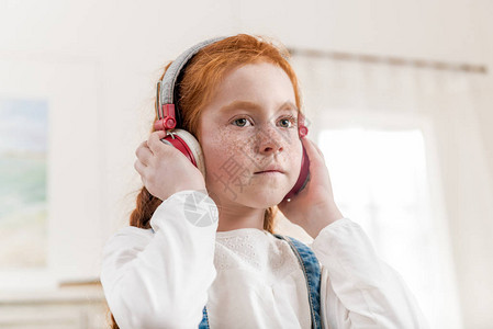 在家戴耳机听音乐的小女孩肖像图片