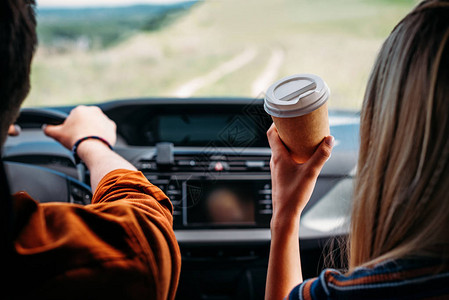 男子驾驶汽车时其女友坐在旁边用纸杯咖图片