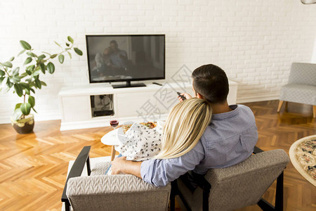 情侣在客厅看电视的背影背景图片