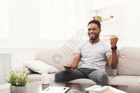 年轻非洲美国人在沙发上看电视图片